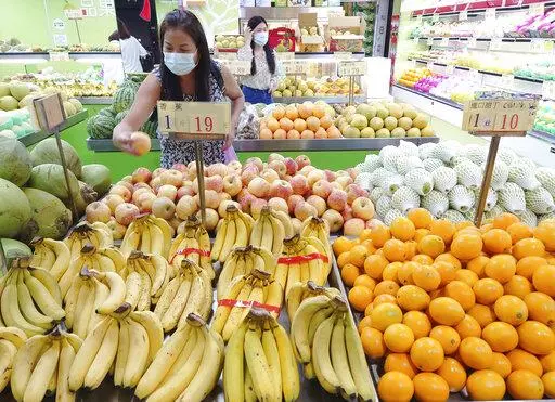 Customers buy fruit at a stall in Taipei, Taiwan, Sept. 20, 2021. China has blocked imports of citrus and fish from Taiwan in retaliation for a visit to the self-ruled island by a top American lawmaker but avoided sanctions on Taiwanese processor chips for Chinese assemblers of smartphones and other electronics, a step that would send shockwaves through the global economy. (AP Photo/Chiang Ying-ying, File)