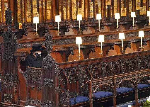 Britain's Queen Elizabeth II sits alone in St. George's Chapel during the funeral of Prince Philip, the man who had been by her side for 73 years, at Windsor Castle, Windsor, England, Saturday April 17, 2021. In retrospect, it seems Queen Elizabeth II was preparing us all along for her death. Whether it was due to age, ill health or a sense that the end was near, she spent much of the last two years tying up loose ends, making sure the family firm would keep ticking along. (Jonathan Brady/Pool v