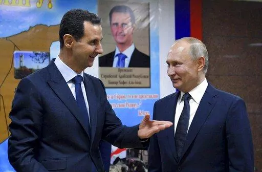 Syrian President Bashar Assad, left, gestures while speaking to Russian President Vladimir Putin during their meeting in Damascus, Syria, Jan. 7, 2020. The next chapter of the war in Ukraine could see Russia bringing in greater numbers of battle-hardened fighters from Syria, observers say. (Alexei Druzhinin, Sputnik, Kremlin Pool Photo via AP, File)