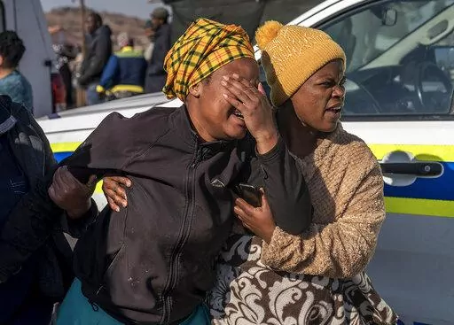 A woman weeps at the scene of an overnight bar shooting in Soweto, South Africa, Sunday July 10, 2022. A mass shooting at a tavern in Johannesburg's Soweto township has killed 15 people and left others in critical condition, according to police.  
Police say they are investigating reports that a group of men arrived in a minibus taxi and opened fire on some of the patrons at the bar shortly after midnight Sunday.  (AP Photo/Shiraaz Mohamed)