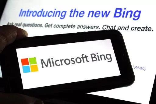 The Microsoft Bing logo and the website's page are shown in this photo taken in New York on Tuesday, Feb. 7, 2023. Microsoft is ready to take its new Bing chatbot mainstream — less than a week after making major fixes to stop the artificially intelligent search engine from going off the rails. The company said Wednesday, Feb. 22, it is bringing the new AI technology to its Bing smartphone app, as well as the app for its Edge internet browser. (AP Photo/Richard Drew)