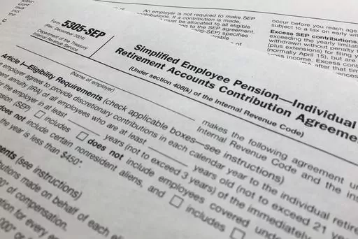 In this April 2, 2018, file photo, an IRS Form 5305, Simplified Employee Pension — Individual Retirement Accounts Contribution Agreement is shown in New York. Companies have long helped their workers save for retirement through 401(k)s and other workplace plans. But recent SECURE 2.0 legislation has blessed a newer trend: employers creating emergency savings options that could encourage workers to save more and avoid raiding their retirement funds. (AP Photo/Jenny Kane, File)