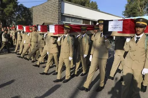 Syrian student officers carry the coffins of their comrades who were killed on Thursday in a drone attack that hit a military graduation ceremony, during a mass funeral procession in Homs, Syria, Friday, Oct. 6, 2023. Family members of some of the victims of deadly drone attacks on a crowded military graduation that killed scores gathered outside a military hospital in this central city Friday to collect the bodies of their loved ones who lost their lives in one of Syria's deadliest single attac