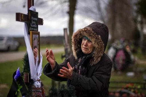 Valentyna Nechyporenko, 77, mourns at the grave of her 47-year-old son Ruslan, during his funeral at the cemetery in Bucha, on the outskirts of Kyiv, Monday, April 18, 2022. Ruslan was killed by Russian army on March 17 while delivering humanitarian aid to his neighbours in the streets of Bucha. (AP Photo/Emilio Morenatti)