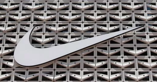 The Nike logo is shown on a store in Miami Beach, Fla. on Aug. 8, 2017. An agreement to weed out global tax havens and force multinational corporations, among them Apple and Nike, to pay a minimum tax has been weakened by loopholes and will raise only a fraction of the revenue that was envisioned, a tax watchdog backed by the European Union has warned. (AP Photo/Alan Diaz, File)