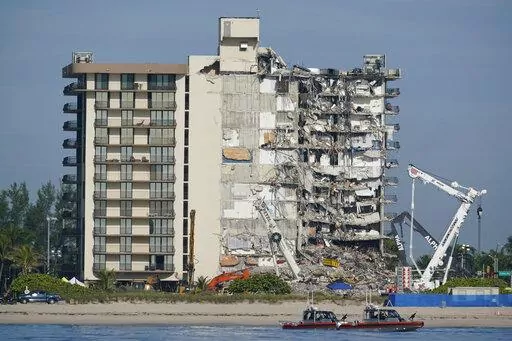 Coast Guard boats patrol in front of the partially collapsed Champlain Towers South condo building, July 1, 2021, in Surfside, Fla. A nearly $1 billion tentative settlement has been reached in a class-action lawsuit brought by families of victims and survivors of last June's condominium collapse in Surfside, Fla., an attorney said Wednesday, May 11, 2022. (AP Photo/Mark Humphrey, File)