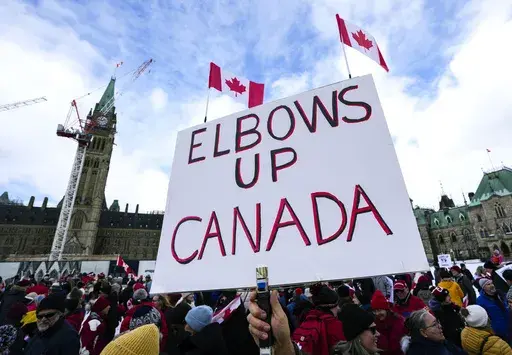 A participant holds an "Elbows Up Canada" sign during rally in response to U.S. President Donald Trump's threats to Canadian sovereignty, on Parliament Hill in Ottawa, on Sunday, March 9, 2025. (Justin Tang/The Canadian Press via AP)