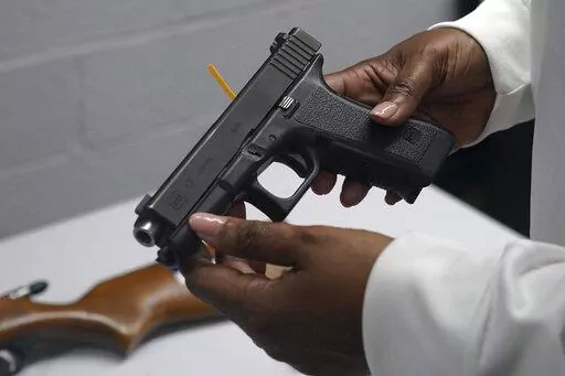 A handgun from a collection of illegal guns is reviewed during a gun buyback event in Brooklyn, N.Y., May 22, 2021. The Supreme Court, Thursday, June 23, 2022, struck down a restrictive New York gun law in a major ruling for gun rights. (AP Photo/Bebeto Matthews, FIle)