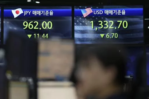 A currency trader watches computer monitors near the screens showing the foreign exchange rates at a foreign exchange dealing room in Seoul, South Korea, Friday, May 19, 2023. (AP Photo/Lee Jin-man)
