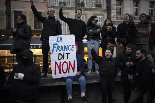 A woman holds a sign reading "France says no" during a demonstration in Marseille, southern France, Thursday, March 16, 2023. With President Emmanuel Macron thousands of miles away in China, French protesters and unions returning to the streets continue to reveal cracks in his domestic political authority. Hundreds of thousands are expected again for the 11th day of nationwide resistance to raising the retirement age from 62 to 64 Thursday, April 6 as the controversial law is being considered by