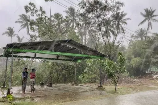 Two children stand under a roadside shelter to protect from rain before Cyclone Mocha hits in Sittwe, Rakhine State, on May 14, 2023. The United Nations has warned that far too little aid is reaching cyclone-hit areas of Myanmar and the country could face a major food crisis soon if farmers are unable to plant crops. Cyclone Mocha struck the western state of Rakhine and nearby regions last month, killing hundreds of people and damaging thousands of dwellings. (AP Photo, File)