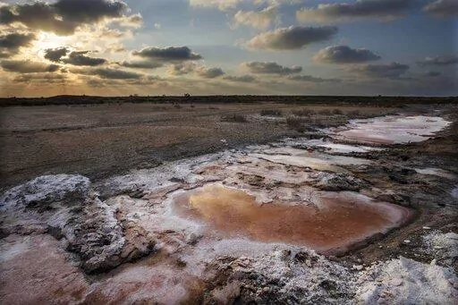 Farmland inundated with saltwater, gradually eats away the soil in the Mediterranean town of Mutubes, in Kafr el-Sheikh province, Egypt, Friday, Sept. 9, 2022. The impact of climate change has long been obvious to farmers, in the creeping salt that eats away roots and cakes their fields, turning them barren. (AP Photo/Nariman El-Mofty)