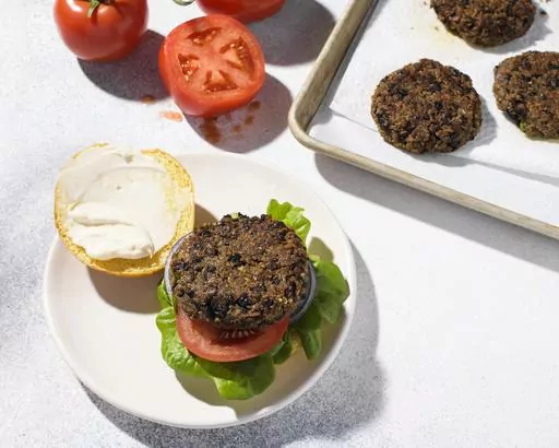 This image released by Milk Street shows a recipe for quinoa and black bean burgers. (Milk Street via AP)