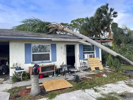 In this photo provided by Cheynne Prevatt, Prevatt's home, seen Thursday, Sept. 29, 2022, was damaged by Hurricane Ian and by a fallen palm tree, making it uninhabitable, in Englewood, Fla. (Cheynne Prevatt via AP)