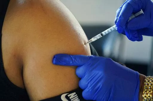 A Jackson, Miss., resident receives a Pfizer booster shot from a nurse at a vaccination site Feb. 8, 2022. The Biden administration hopes to make getting a COVID-19 booster as routine as going in for the yearly flu shot. (AP Photo/Rogelio V. Solis, File)