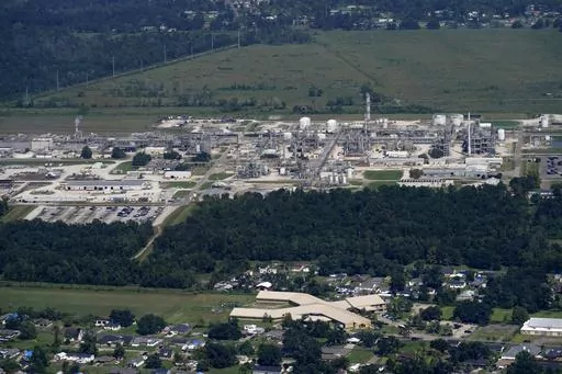 The Fifth Ward Elementary School and residential neighborhoods sit near the Denka Performance Elastomer Plant, back, in Reserve, La., Sept. 23, 2022. In what could prove a significant move for communities facing air pollution, the Environmental Protection Agency proposed on Thursday, April 6, 2023, that chemical plants nationwide measure certain hazardous compounds that cross beyond their property lines and reduce them when they are too high. (AP Photo/Gerald Herbert, File)
