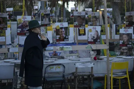 A woman looks at a display of empty chairs representing hostages held by the Hamas militant group in the Gaza Strip in Tel Aviv, Israel, Friday, Jan. 24, 2025. (AP Photo/Maya Alleruzzo)