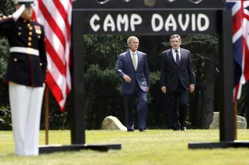 President George W. Bush, left, and British Prime Minister Gordon Brown walk to a joint press availability at Camp David, Md., July 30, 2007. (AP Photo/Charles Dharapak, File)
