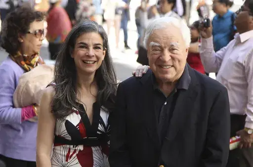 Arthur Frommer, 83, and his daughter, Pauline Frommer, 46, pose among tourists in the Wall Street area in New York, May 20, 2012. (AP Photo/Seth Wenig, File)