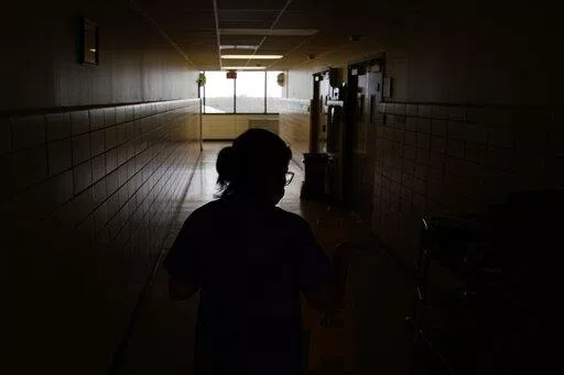A chief nursing officer walks down a hallway in the recently reopened emergency room at a hospital  in Houma, La., on Friday, Sept. 3, 2021. Patients worried about getting smacked with an unexpected bill after emergency care gained a layer of protection in January 2022 from a new federal law. The No Surprises Act prevents doctors or hospitals in many situations from billing insured patients higher rates because the care providers are not in their insurer’s coverage network. (AP Photo/John Loch