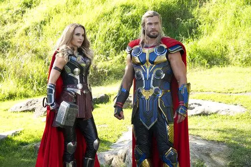 This image released by Marvel Studios shows Natalie Portman, left, and Chris Hemsworth in a scene from "Thor: Love and Thunder." (Jasin Boland/Marvel Studios-Disney via AP)