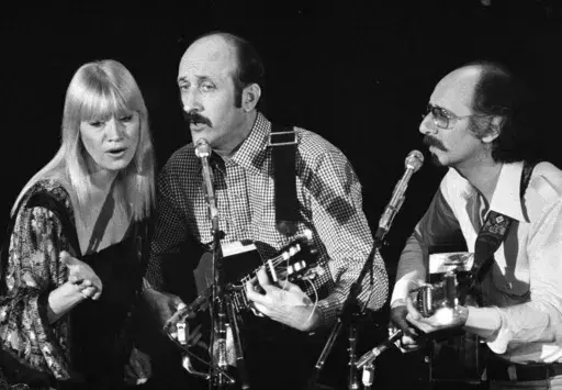Folk trio Peter, Paul and Mary, from left, Mary Travers, Paul Stookey and Peter Yarrow, perform at a Los Angeles benefit to aid to Cambodian refugees on Jan. 30, 1980. (AP Photo/George Brich, File)