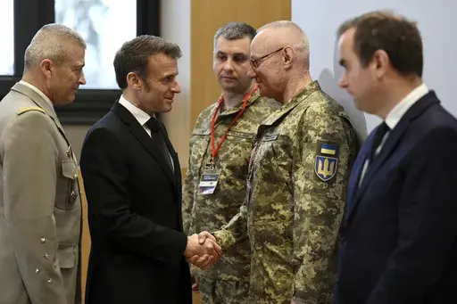 French President Emmanuel Macron, second left, , shakes hands with Colonel-General Ruslan Khomchak, First Deputy Secretary of the National Security and Defense Council of Ukraine, as French Defense Minister Sebastien Lecornu, right, and Chief of Staff of the French Armed Forces Thierry Burkhard, left, look on during a meeting on the conflict in Ukraine at the Musee de la Marine as part of the Paris Defense and Strategy Forum in Paris, Tuesday, March 11, 2025. (Sarah Meyssonnier/Pool via AP)