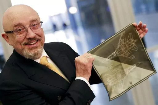 CAPTION CORRECTS THE ID - Ukraine's Defense Minister Oleksiy Reznikov shows a handkerchief with a F-35 fighter jet when heading to a meeting with United States Secretary of Defense Lloyd Austin, on the sidelines of a NATO headquarters in Brussels, Tuesday, Feb. 14, 2023. (AP Photo/Olivier Matthys, Pool)