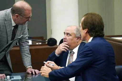 John Davis, former director of the Mississippi Department of Human Services, confers with defense attorneys Merrida Coxwell, right, and Charles Mullins, left, in Jackson, Miss., on Sept. 22, 2022. Davis pleaded guilty to state and federal charges in a conspiracy to misspend tens of millions of dollars that were intended to help needy families in one of the poorest states in the U.S. as part of the largest public corruption case in Mississippi history. (AP Photo/Rogelio V. Solis, File)
