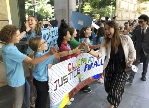 Kelsey Juliana, of Eugene, Ore., a lead plaintiff who is part of a lawsuit by a group of young people who say U.S. energy policies are causing climate change and hurting their future, greets supporters outside a federal courthouse, June 4, 2019, in Portland, Ore. A federal judge ruled on Thursday, June 1, 2023, that a lawsuit brought by young Oregon-based climate activists can proceed to trial years after they first filed the lawsuit in an attempt to hold the nation’s leadership accountable fo