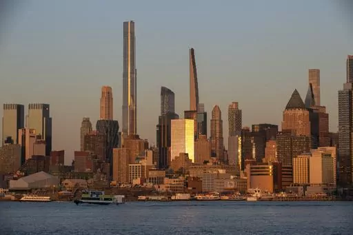 Light from the setting sun reflects off the buildings in the borough of Manhattan in New York City, as seen from the Weehawken Pier in Weehawken, N.J., on Wednesday, March 22, 2023. Living in a high-cost city can strain your finances, but three tips can help you thrive. Consider shopping at wholesale stores for groceries, even if you don’t have a car. Take advantage of discounts that cultural institutions such as museums and theaters often offer to residents through a city ID or library card. 