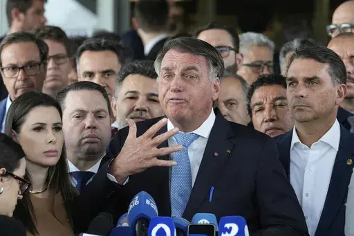 Brazil's former President Jair Bolsonaro speaks to the press at Congress in Brasilia, Brazil, Wednesday, March 26, 2025, after panel of Brazil Supreme Court justices accepted charges against him over an alleged attempt to stay in office after his 2022 election defeat. (AP Photo/Eraldo Peres)
