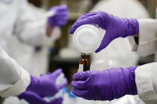 Eva Stebel, water researcher, pours a water sample into a smaller glass container for experimentation as part of drinking water and PFAS research at the U.S. Environmental Protection Agency Center For Environmental Solutions and Emergency Response on Feb. 16, 2023, in Cincinnati. The 3M chemical company announced Thursday, June, 22, 2023 a $10.3 billion settlement with U.S. water utilities and agencies over PFAS pollution that will allow them to test and treat drinking water contaminated with th