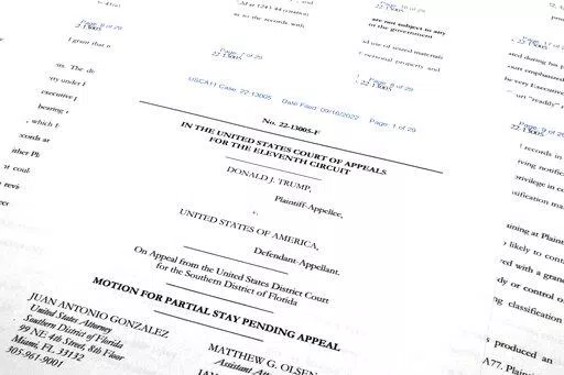 Pages from the Justice Department's motion to the 11th Circuit U.S. Court of Appeals in Atlanta are photographed Friday, Sept. 16, 2022. The Justice Department asked the federal appeals court to lift a judge's order that temporarily barred it from reviewing a batch of classified documents seized during an FBI search of former President Donald Trump's Florida home last month. (AP Photo/Jon Elswick)