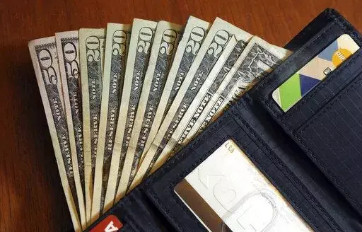 In this June 15, 2018, file photo, cash is fanned out from a wallet in North Andover, Mass. A personal loan can be a good option when you need money, but it typically requires strong credit and high income to qualify. What if you don’t meet the requirements for a personal loan? Consider several alternative ways to get money, such as family loans and cash advances.   (AP Photo/Elise Amendola, File)