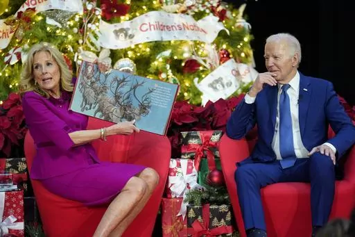 First lady Jill Biden, accompanied by President Joe Biden, reads "Twas the Night Before Christmas" at Children's National Hospital, Friday, Dec. 22, 2023, in Washington. (AP Photo/Evan Vucci)