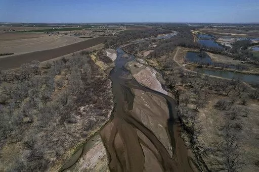 The South Platte River flows on Thursday, April 28, 2022, in Fort Morgan, Colo. As climate change-fueled megadrought edges eastward, Nebraska wants to divert water in Colorado by invoking an obscure, 99-year-old compact between the states that allows Nebraska to seize Colorado land along the South Platte River to build a canal. (AP Photo/Brittany Peterson)