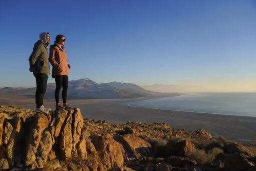 Antelope Island State Park visitors view the the receding edge of the Great Salt Lake Friday, Jan. 28, 2022, at Antelope Island, Utah. The largest natural lake west of the Mississippi is shrinking past its lowest levels in recorded history, raising fears about toxic dust, ecological collapse and economic consequences. But the Great Salt Lake may have some new allies: conservative Republican lawmakers. (AP Photo/Rick Bowmer)