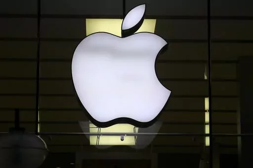 The Apple logo is illuminated at a store in the city center of Munich, Germany, Dec. 16, 2020. Apple Inc. is raising the prices for its AppleTV+ streaming and Arcade gaming plans, as well as its bundled Apple One service that includes streaming, music and other subscriptions. (AP Photo/Matthias Schrader, File)