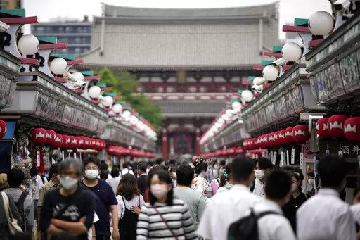 Visitors walk along a shopping street at the Asakusa District, Friday, June 10, 2022, in Tokyo. The dollar is near its highest level in more than two decades against a key index measuring six major currencies, including the euro and Japanese yen. (AP Photo/Eugene Hoshiko, File)