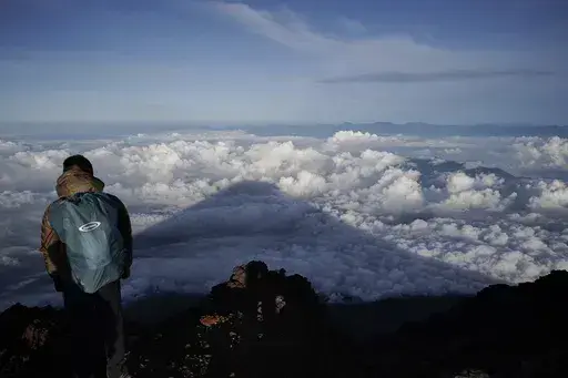 The shadow of Mount Fuji is cast on clouds hanging below the summit Aug. 27, 2019, in Japan. Three bodies were found inside a crater at the summit of Mount Fuji, Japan’s most famous mountain, with one of them already brought down from the slopes, police said Thursday, June 27, 2024. (AP Photo/Jae C. Hong, File)
