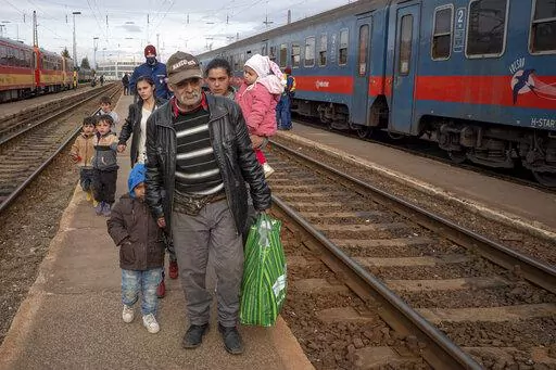 Refugees fleeing the war from neighboring Ukraine walk on a platform after disembarking from a train in Zahony, Hungary, Wednesday, March 2, 2022. At the train station in the Hungarian town of Zahony on Wednesday, more than 200 Ukrainians with disabilities — residents of two care homes in Ukraine's capital of Kyiv — disembarked into the cold wind of the train platform after an arduous escape from the violence gripping Ukraine. (AP Photo/Balazs Kaufmann)