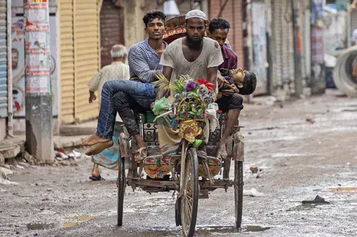 FILE -People carry an injured protester in a cycle rickshaw to a hospital after he was shot at by the police during a protest against Prime Minister Sheikh Hasina and her government, in Dhaka, Bangladesh, Aug. 5, 2024. (AP Photo/Rajib Dhar), File)