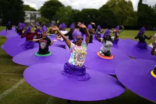 Members of the Mahogany carnival group take part in a rehearsal for their upcoming performance at the Platinum Jubilee Pageant, at Queens Park Community School, in north London, Saturday, May 28, 2022. (AP Photo/Matt Dunham)