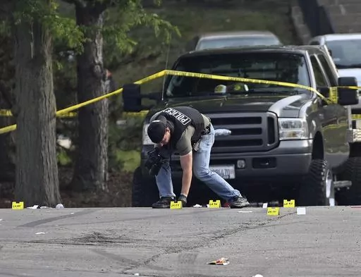 A police officer works the scene of an overnight mass shooting at a strip mall in Willowbrook, Ill., June 18, 2023. A suburban Chicago teen is facing weapons charges in connection with a June shooting where one person died and 22 others were injured, authorities said Friday, Oct. 6, 2023. (AP Photo/Matt Marton, File)