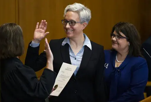 Tina Kotek, center, was accompanied by her wife Aimee Wilson, right, as Kotek was sworn in as Oregon governor at the state Capitol building in Salem, Ore., on Monday, Jan. 9, 2023. (Dave Killen/The Oregonian via AP, Pool)