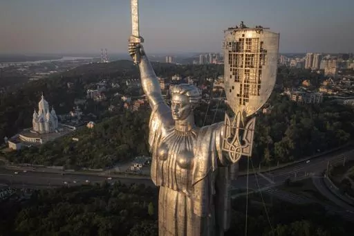 Workers install the Ukrainian coat of arms on the shield in the hand of the country's tallest stature, the Motherland Monument, after the Soviet coat of arms was removed, in Kyiv, Ukraine, Sunday, Aug. 6, 2023. Ukraine is accelerating efforts to erase the vestiges of centuries of Soviet and Russian influence from the public space amid the Russian invasion of Ukraine by pulling down monuments and renaming hundreds of streets to honor home-grown artists, poets, military chiefs, and independence le
