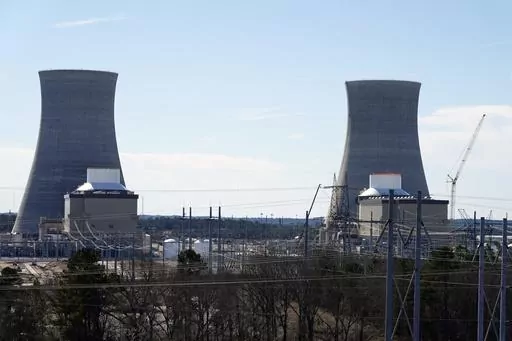 Units 3, left, and 4 and their cooling towers stand at Georgia Power Co.'s Plant Vogtle nuclear power plant, Jan. 20, 2023, in Waynesboro, Ga. Residential customers of Georgia's largest electrical utility could see their bills rise another $9 a month to pay for a new nuclear power plant under a deal announced Wednesday, Aug. 30. Georgia Power Co. said customers would pay $7.56 billion more for Plant Vogtle construction costs under the agreement with utility regulatory staff. (AP Photo/John Bazem