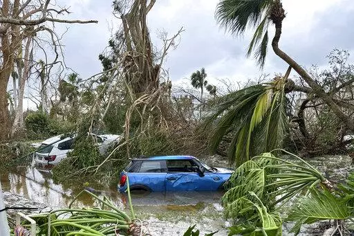 In this undated image from video, damaged vehicles and debris are seen on Sanibel Island, Fla. Chuck Larsen's home was slammed by Hurricane Ian and he spent a harrowing few days on the isolated island before being evacuated over the weekend. (Chuck Larsen/SantivaChronicle.com via AP)