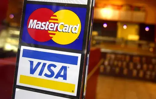 This April 22, 2005, file photo, shows logos for MasterCard and Visa credit cards at the entrance of a New York coffee shop. Mastercard and Visa are suspending their operations in Russia, the companies said Saturday, March 5, 2022, in the latest blow to the country's financial system after its invasion of Ukraine. (AP Photo/Mark Lennihan, File)